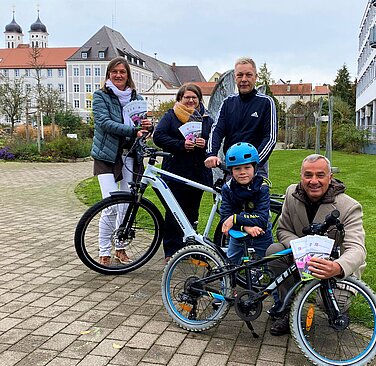 stadt_guenzburg_etabliert_bikeleasing-angebot_fuer_mitarbeitende Die Stadt Günzburg bietet Mitarbeitenden seit Kurzem das Leasen von Diensträdern an. Klimaschutzmanagerin und Radverkehrsbeauftragte Daniela Fischer, die zuständige Mitarbeiterin der Personalstelle Bettina Klaußer (v. l.) und Oberbürgermeister Gerhard Jauernig (r.) gratulieren Jürgen Gleixner zum neuen Dienstrad. Der freut sich darüber, dass er dieses sowohl geschäftlich als auch für private Radtouren mit Sohn Moritz nutzen kann. Foto: Carmen Willer/Stadt Günzburg