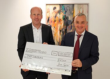 Bezirkstagspräsident Martin Sailer (links) überreichte den Scheck Günzburgs Oberbürgermeister Gerhard Jauernig, der ihn stellvertretend für alle von der Flutkatastrophe betroffenen Gemeinden Schwabens entgegennahm. Foto: Lothar Jander/Sparkasse Schwaben-Bodensee