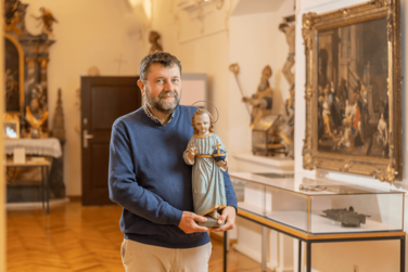 Der 2. Vorsitzende des Historischen Vereins Günzburg, Rudolf Kombosch, berichtet über die Darstellungen des Christkinds in der Kunstgeschichte. Foto: Philipp Röger für die Stadt Günzburg.