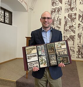 Günzburgs Museumsleiter Dr. Raphael Gerhardt präsentiert die neu erworbene Sammlung historischer Postkarten und Fotografien. Foto: Michael Lindner/Stadt Günzburg