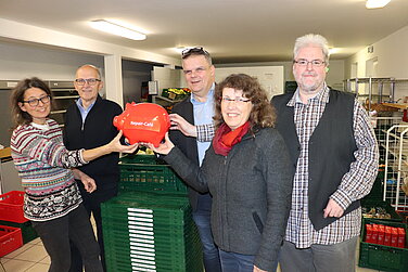 repair-cafe_unterstuetzt_die_tafel Umweltfachkraft Christine Hengeler (Stadt Günzburg), Werkleiter Anton Fink (Kreisabfallwirtschaft), Zweite Bürgermeisterin Dr. Ruth Niemetz und Norbert Mäusle (vhs Günzburg) (v.l.) übergeben dem Geschäftsführer der Caritas Günzburg, Mathias Abel (Bildmitte), ein gut gefülltes Spendenschweinchen. Foto: Caritasverband für die Region Günzburg und Neu-Ulm e. V.