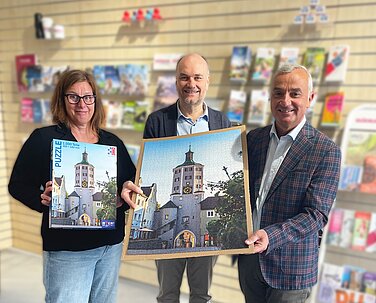 Günzburgs Oberbürgermeister Gerhard Jauernig, Hutter-Trade-Geschäftsführer Hermann Hutter und Anja Hauke (Leiterin Tourist-Information Günzburg-Leipheim) freuen sich über das erste Günzburger Stadtpuzzle, das ab sofort bei der Tourist-Information erhältlich ist. Foto: Michael Lindner/Stadt Günzburg