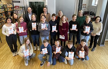 Die jeweiligen Schulsieger beim Kreisentscheid des Vorlesewettbewerbs der 6. Klassen in der Stadtbücherei Günzburg – mit Siegerin Lara Rajic (mittlere Reihe, Vierte von links). Foto: Michael Lindner/Stadt Günzburg