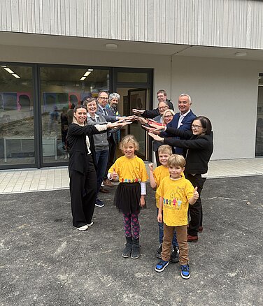 Hereinspaziert! Die Erstklässler Melissa, Henri und Simon freuen sich über das neue Schulgebäude. OB Gerhard Jauernig, die Schulleitung und Vertreter des Stadtrats und der Stadtverwaltung stehen gerne symbolisch Spalier zur Übergabe. Foto: Monika Rudolph/ Stadt Günzburg Monika Rudolph