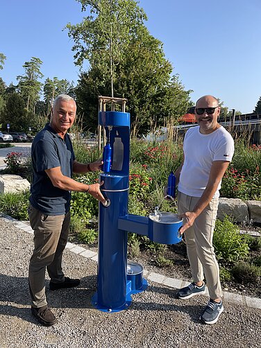 Stadtwerke-Vorstand Lothar Böck (rechts) und Oberbürgermeister Gerhard Jauernig testen den neuen Trinkwasserbrunnen vor dem Waldbad. Foto: Michael Lindner/Stadt Günzburg